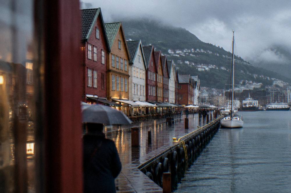 Rain falling on the colourful wooden buildings of the Bergen wharf at dusk