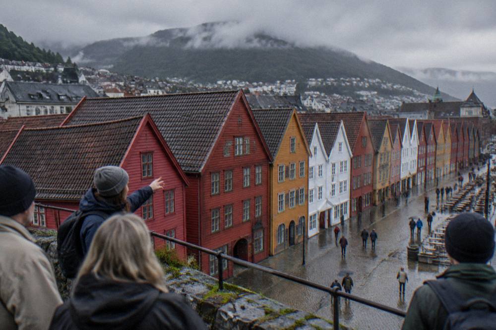 A guide with a small group of visitors stopping at a viewpoint overlooking the coloured warehouses of Bryggen