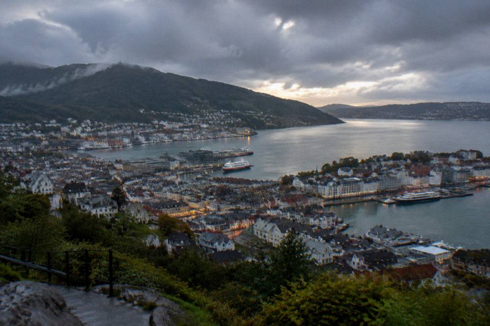 The illuminated harbour and hills of Bergen seen from above at dusk after rain
