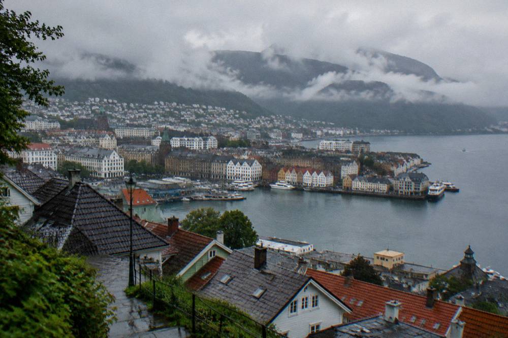 Low clouds and mist wrapping the mountains that surround the city of Bergen above the rooftops