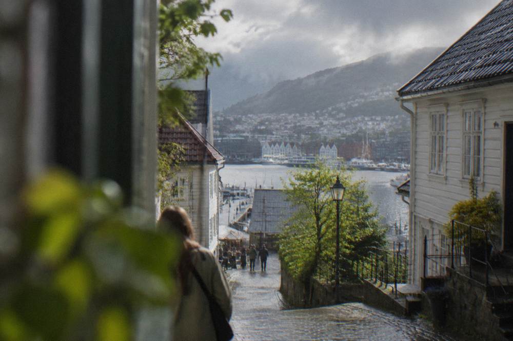 Clear spring sunlight over wooden houses and narrow streets in central Bergen with the harbour beyond