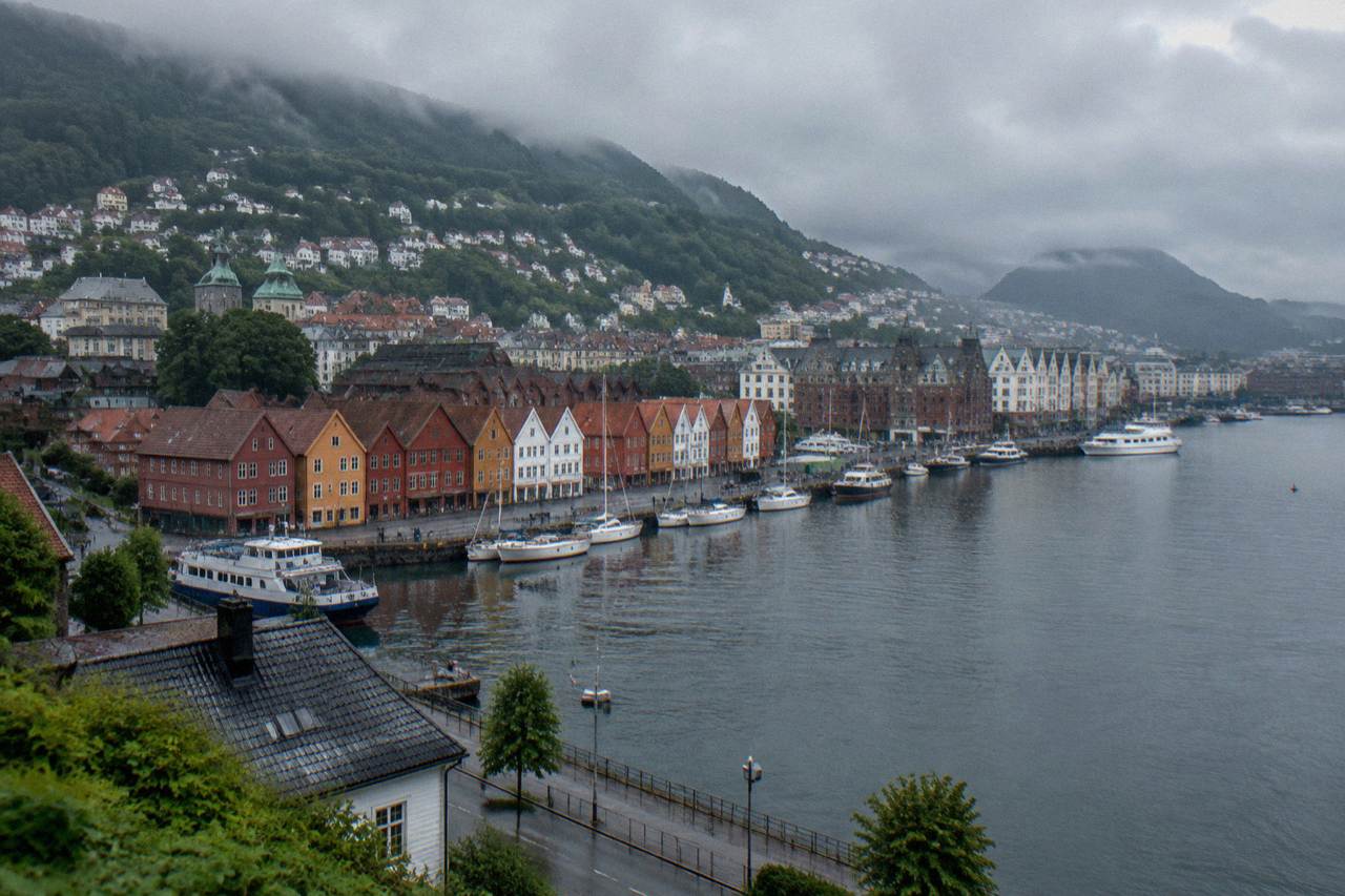 Bergen harbour seen from above on a grey morning, with colourful wooden buildings along the wharf and moored boats