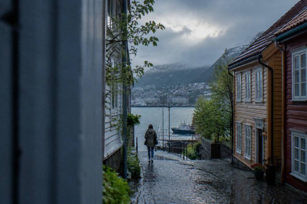 A nearly empty alley between wooden hanseatic buildings in Bergen in soft spring light