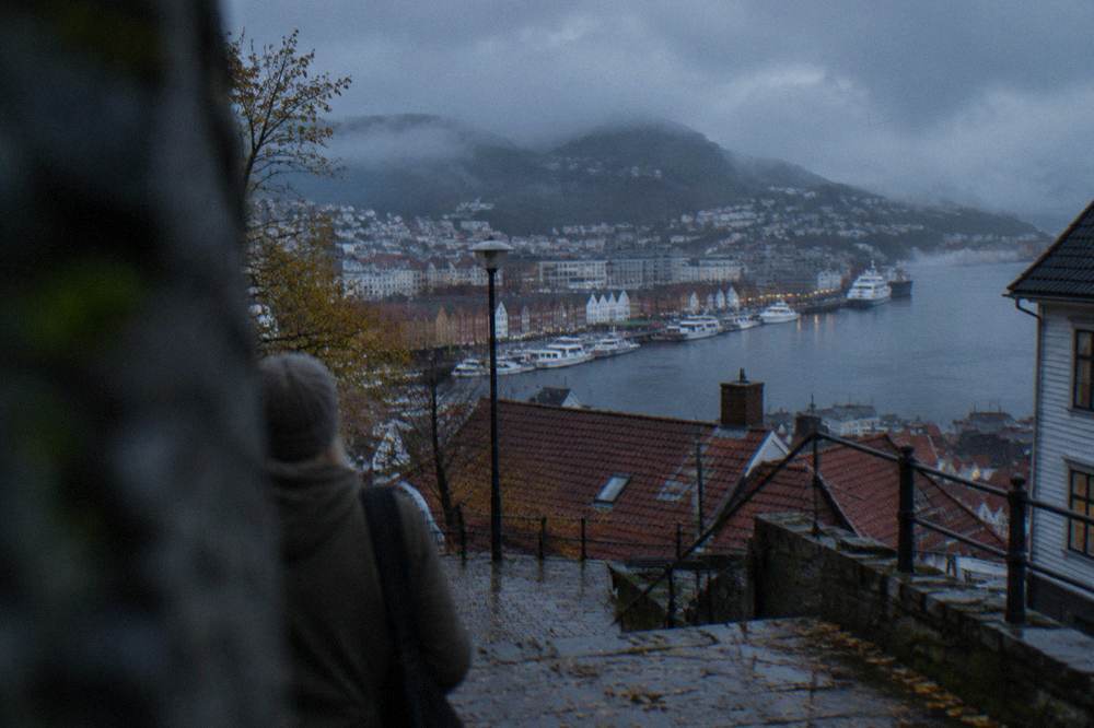 Low rain clouds moving over red rooftops and the harbour in Bergen on an autumn afternoon