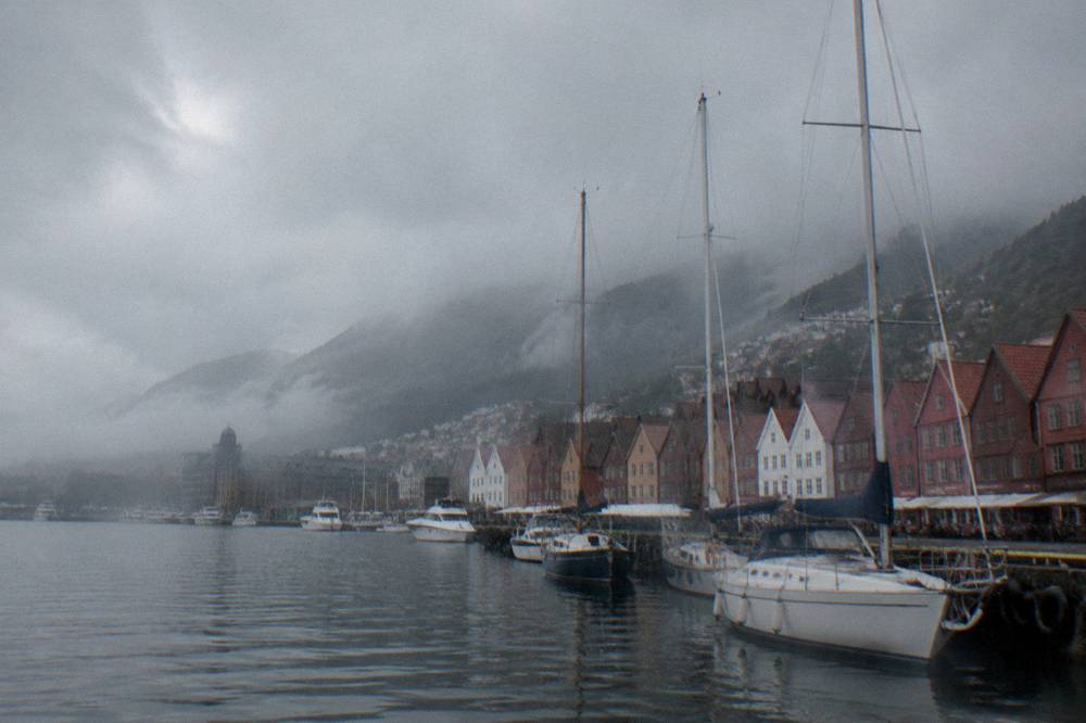 Rain clouds moving over the harbour in Bergen with moored boats below
