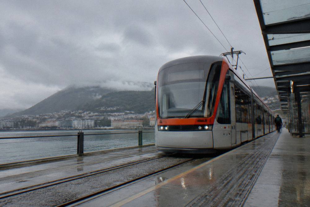 A light rail tram waiting at an airport station platform in Norway