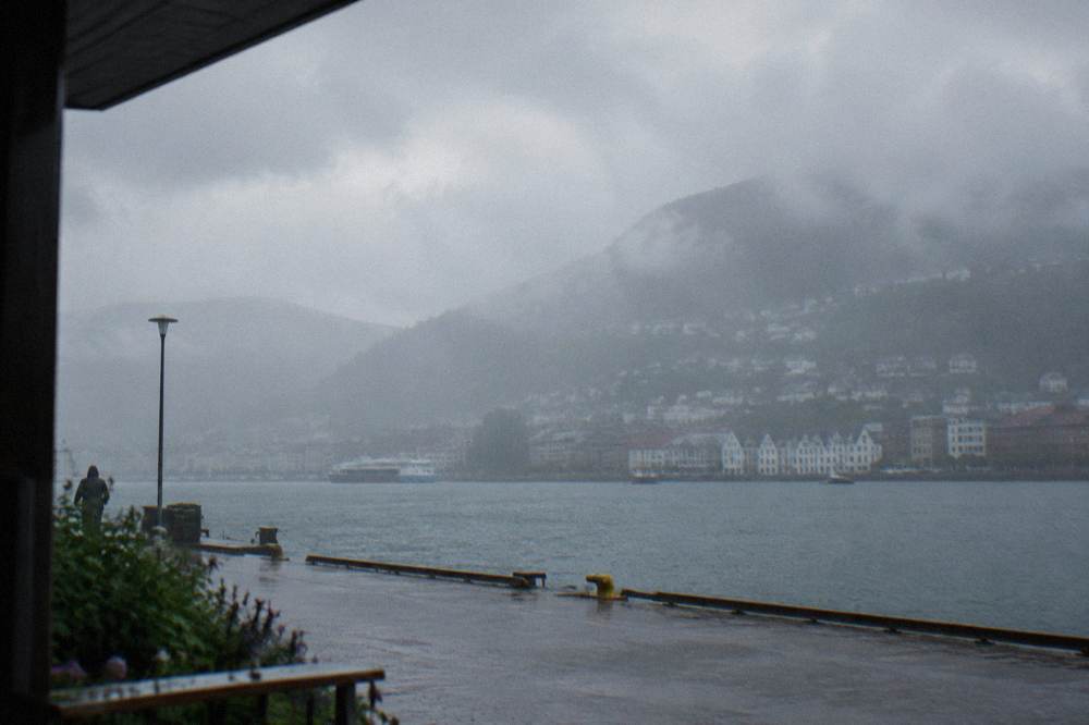 Heavy rain moving across the fjord and mountains surrounding Bergen under grey skies
