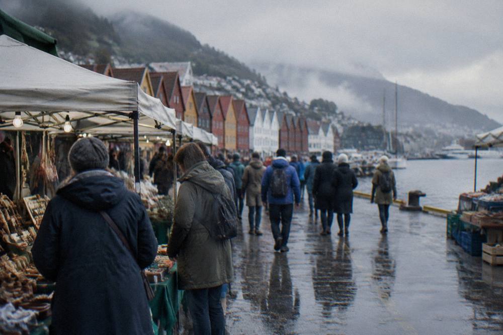 Crowds of visitors browsing stalls along the waterfront in central Bergen on a busy day