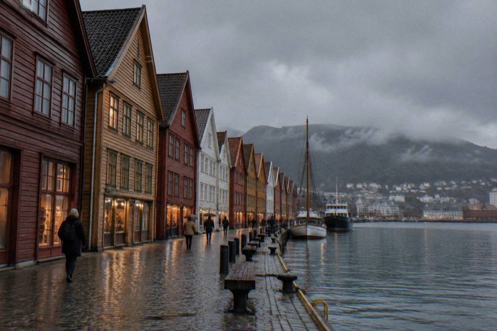 Overcast night sky over Bergen's Bryggen wharf with lit wooden hanseatic buildings