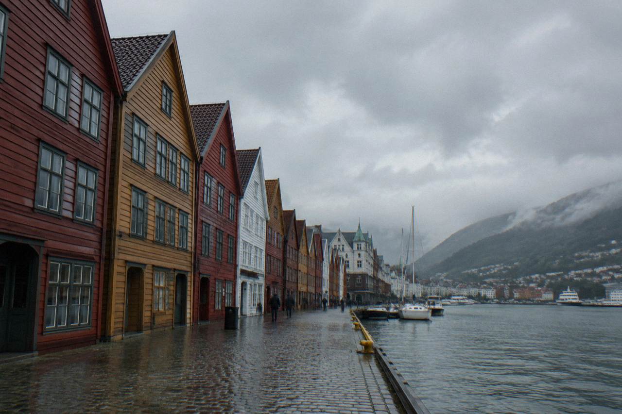 Colourful wooden Hanseatic buildings along the Bryggen wharf in Bergen with the harbour in front