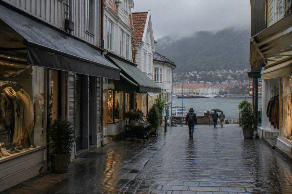 A narrow shopping street in central Bergen with small boutiques under awnings