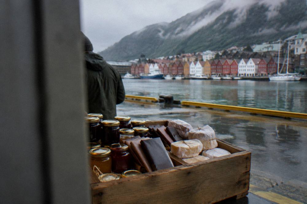 A wooden crate filled with jars of jam, chocolate bars and wrapped cheese ready for travel