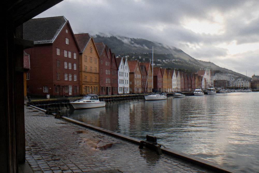 The historic Bryggen wharf buildings in Bergen standing along the water with small boats in front
