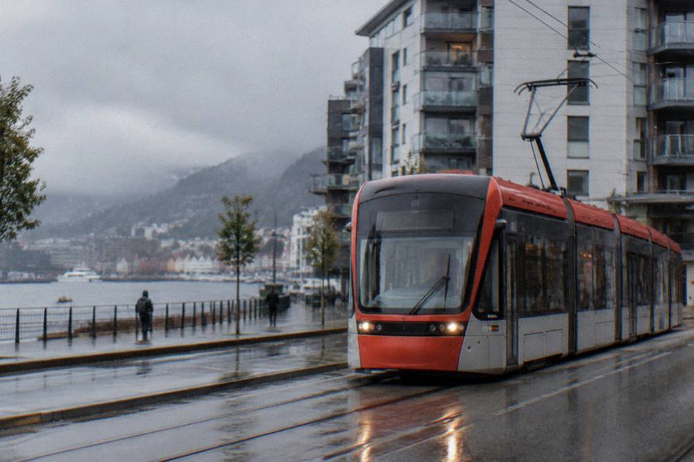 Bybanen light rail tram passing modern apartment buildings on a Bergen street