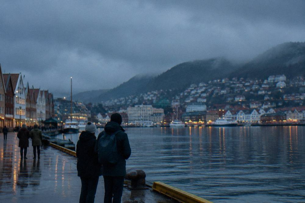 Visitors examining exhibits inside a lit museum gallery in Bergen