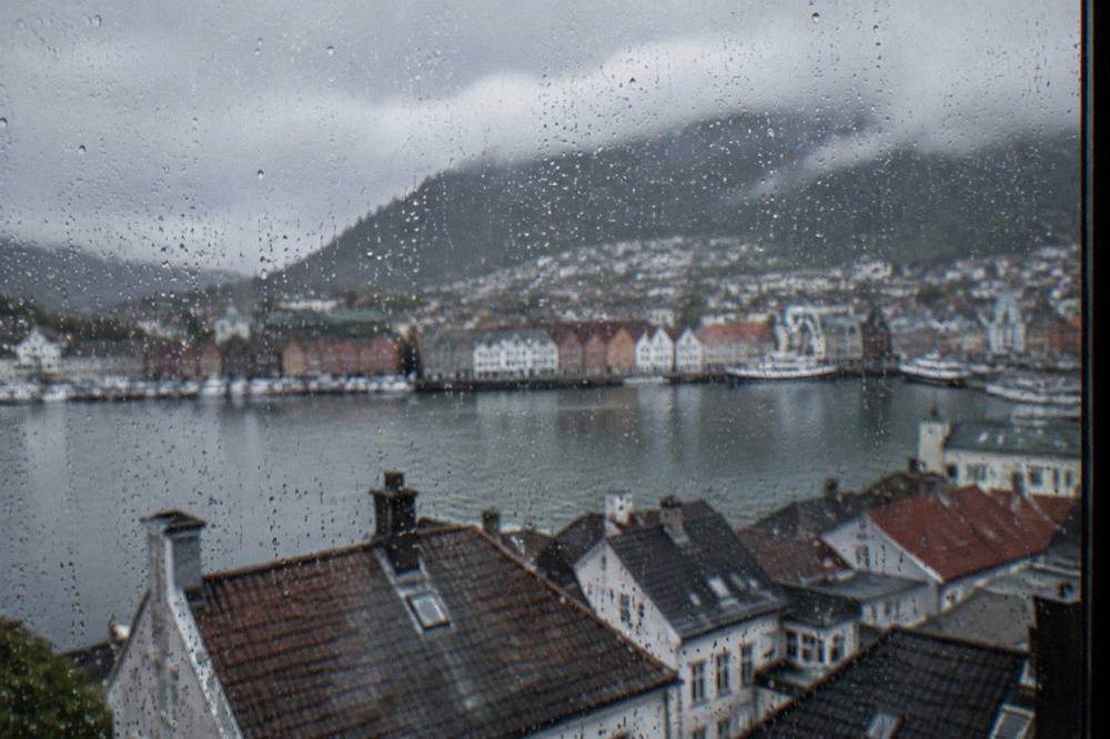 Raindrops on a window with the blurred rooftops of Bergen behind