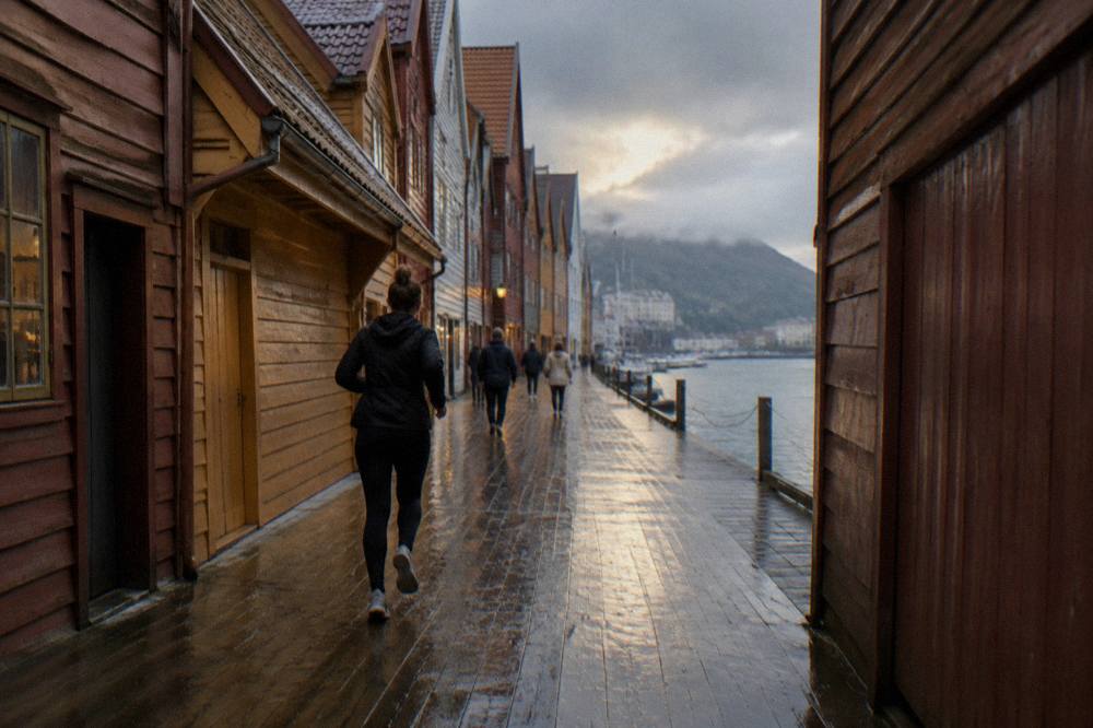 Visitors walking through the narrow wooden passageways between Bryggen's Hanseatic warehouses