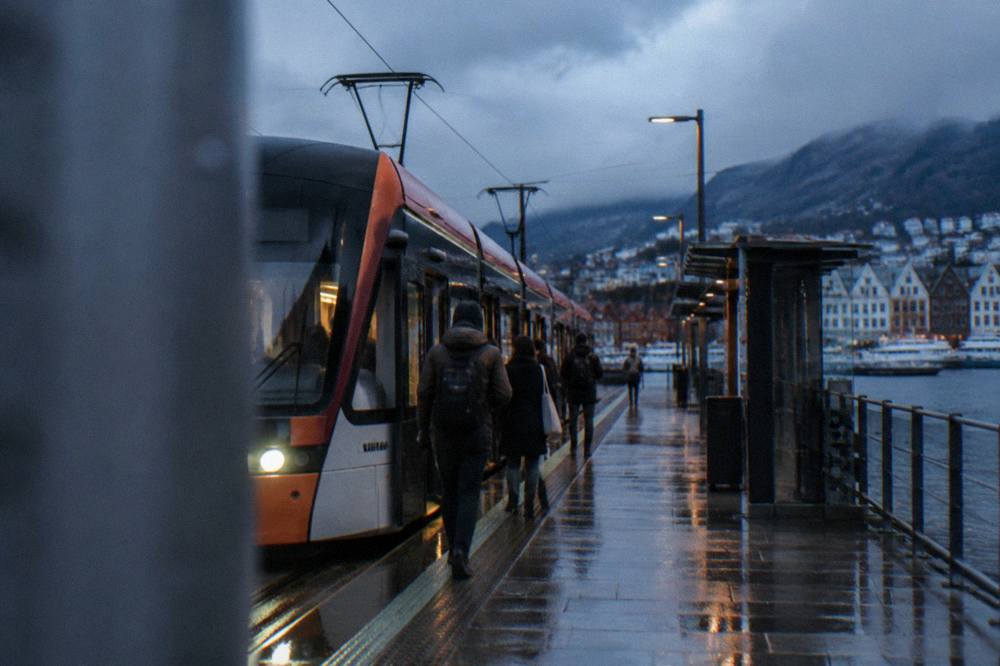 A Bybanen light rail tram waiting at a city-centre stop in Bergen with passengers boarding